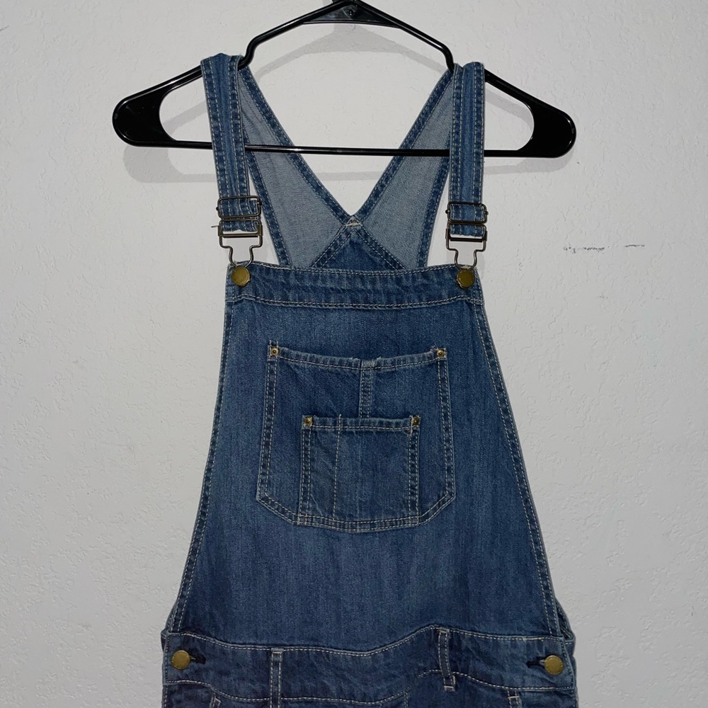 Women's ripped knee length jeans overalls in washed blue